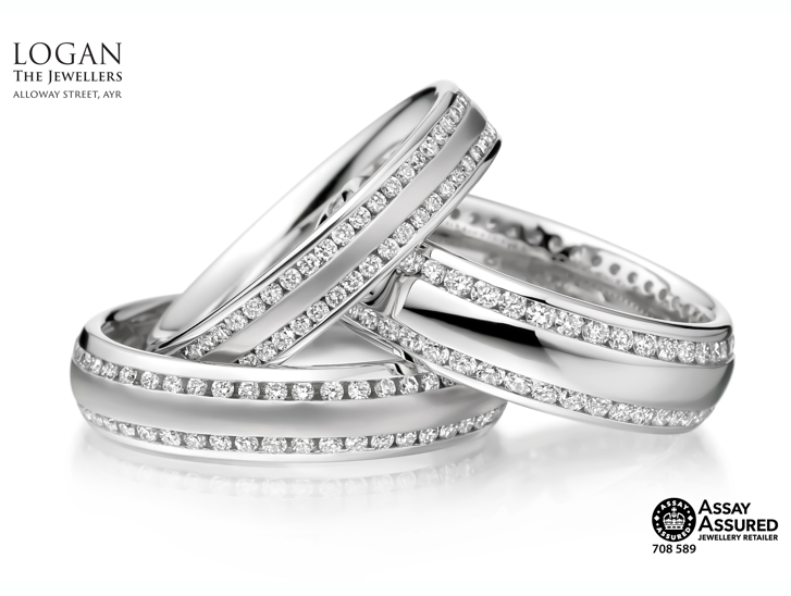 Three silver wedding bands with two thin bands of diamonds on each